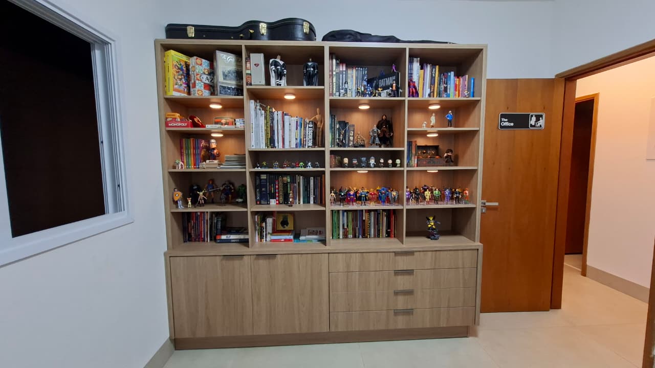 Estante com action figures, livros e quadrinhos da coleção de Alberto Sousa